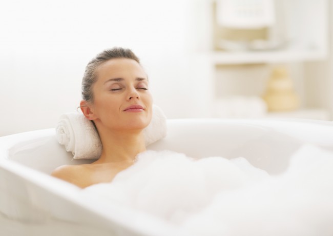 happy young woman relaxing in bathtub